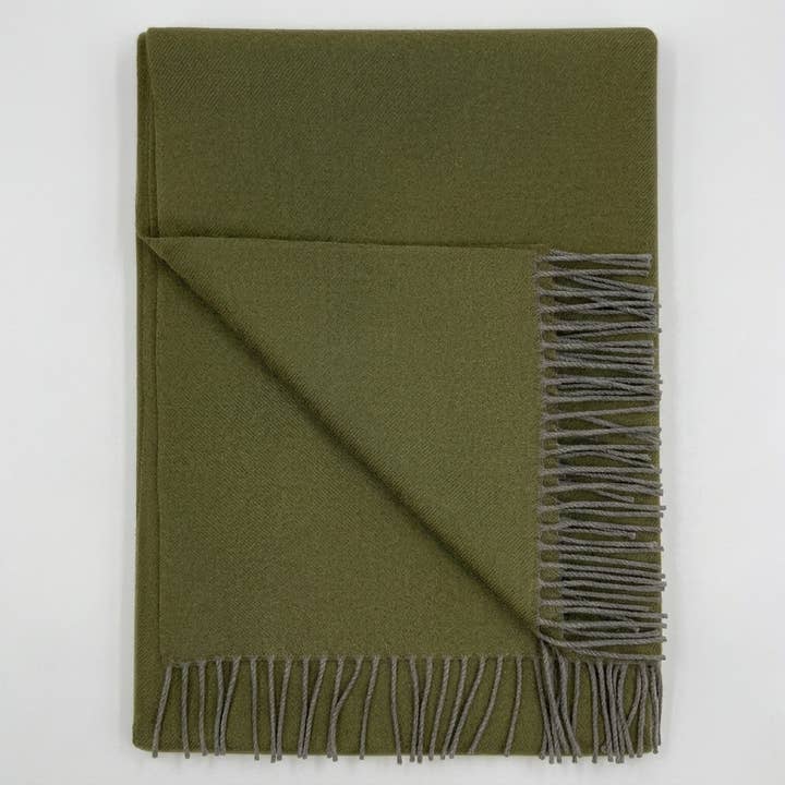 Olive alpaca wool blanket with a subtle basketweave, draped on a neutral background