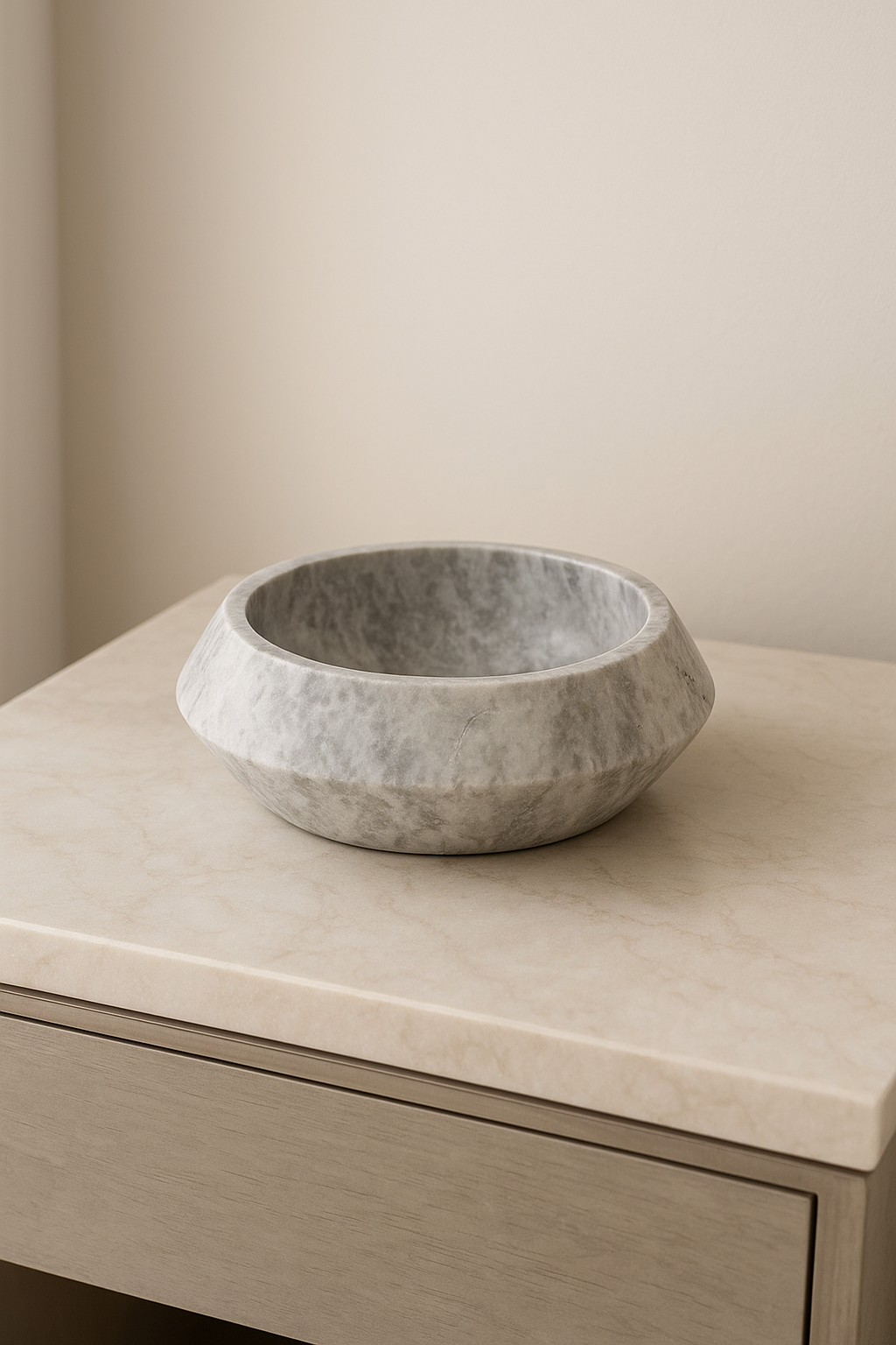 Silver Round Travertine Bowl with a broad rim and gray stone texture resting on a pale stone surface