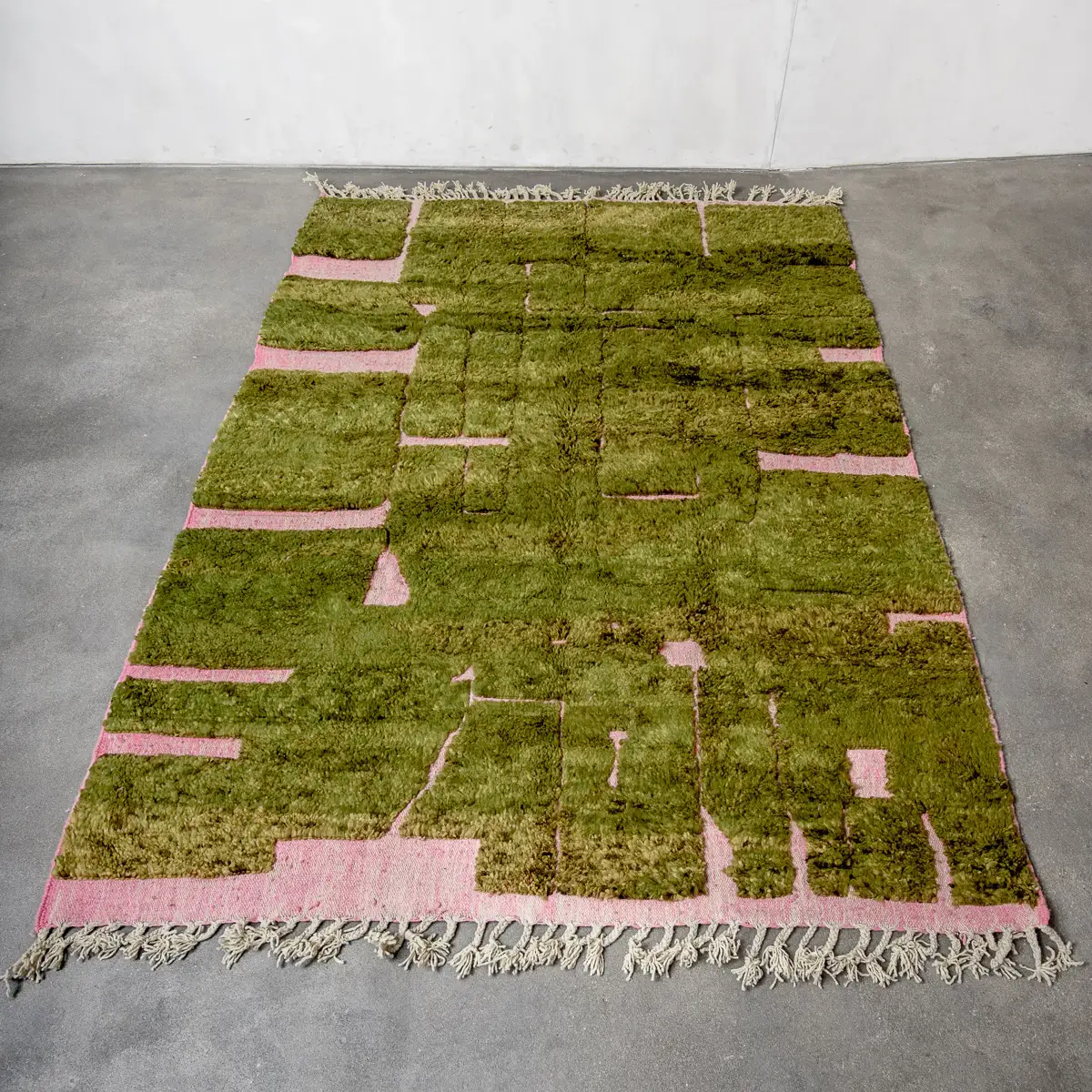 Olive green high-pile Moroccan rug with pink geometric channels and cream fringe