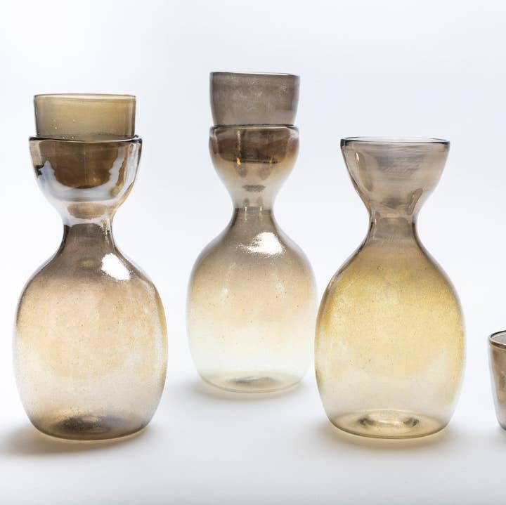 Söt sculptural carafe and cup set on a neutral background
